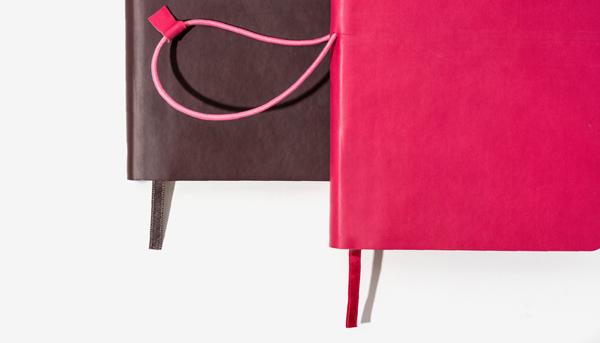 Set of brown and berry pink notebooks with horizontal elastic closing band