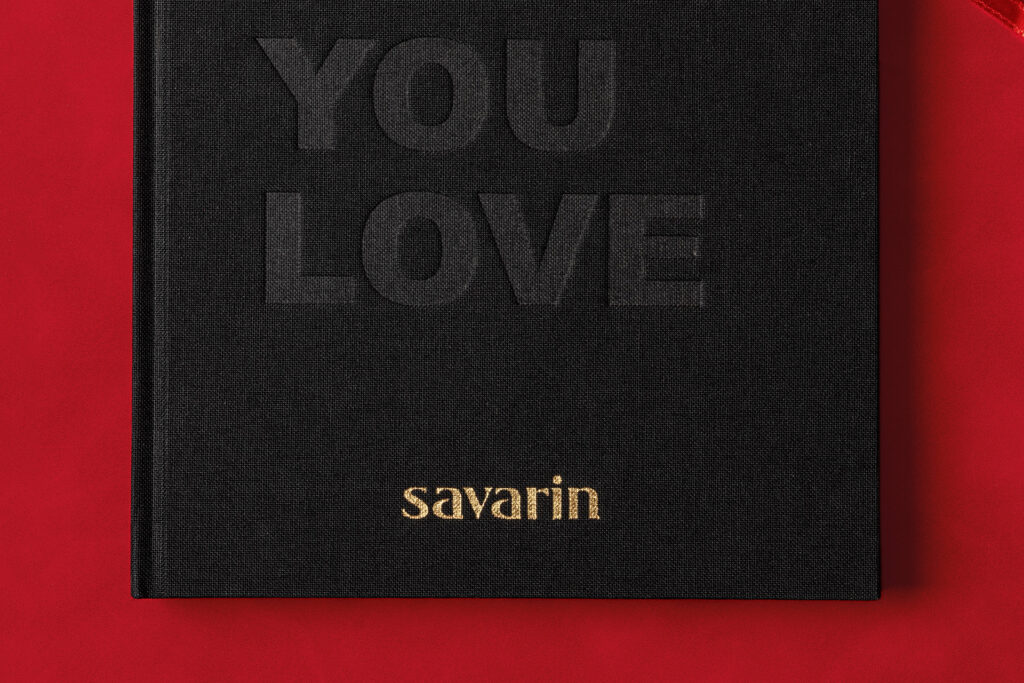  Savarin black clothbound notebook on red background with debossed letters and gold foiled logo