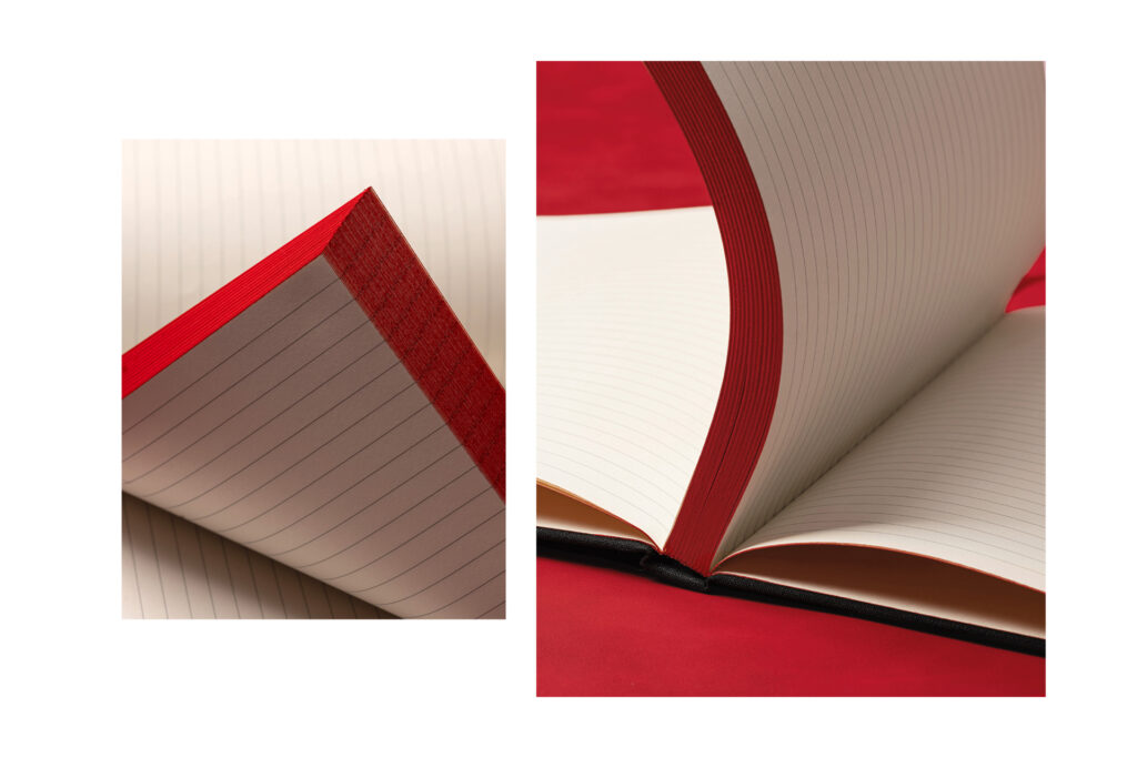 lined notebook pages with red painted edge on red background